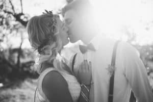 Verliebtes Brautpaar küsst sich bei Sonnenuntergang, fotografiert von Hochzeitsfotografen aus Tirol.