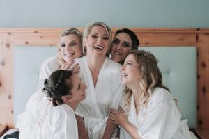 Strahlende Brautteam-Mädels in Badekrobe, Hochzeitsvorbereitungen, Freude, Frauen, Freundschaft, Hochzeitsfotografie.