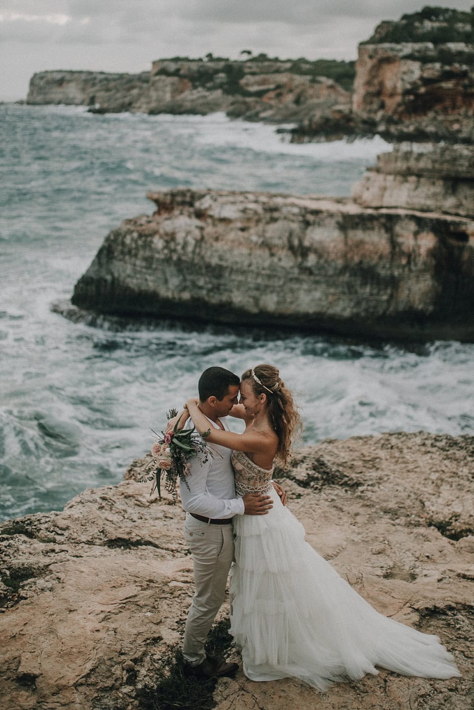 Lustige Hochzeitsfotografie eines Paares am Meer bei Sonnenuntergang in Tirol, Österreich.