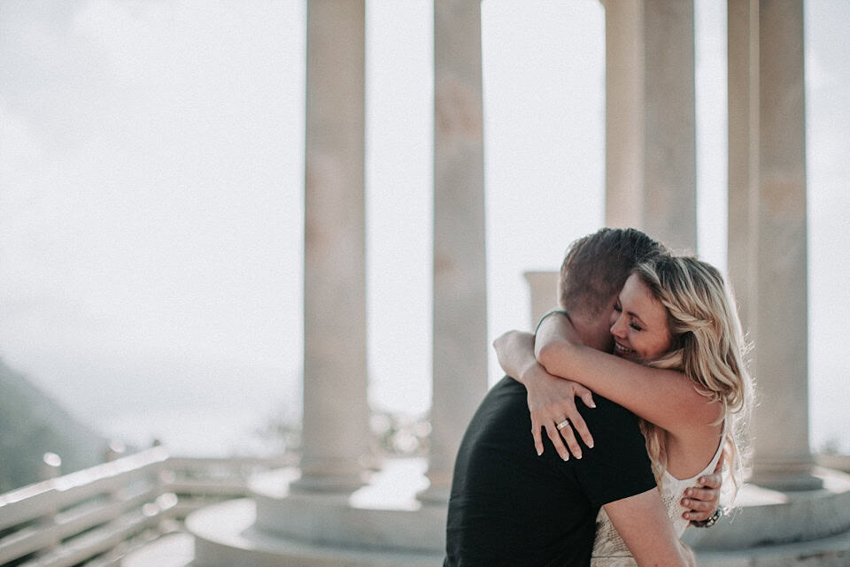 Romantisches Paar beim Umarmungshooting inmitten antiker Säulen.