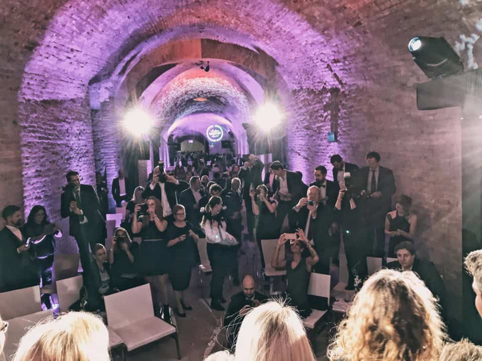 Beeindruckende Hochzeitsgesellschaft in einer alten, lichtdurchfluteten Tunnel-Kirche Tirol Österreich.