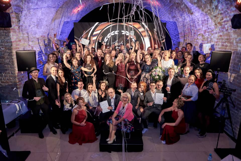 Fröhliche Hochzeitsgesellschaft bei Feier in einer alten Steinhalle, begleitet von Fotografien für unvergessliche Erinnerungen.