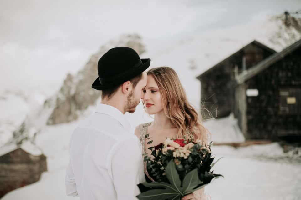 Romantisches Hochzeitsfoto von Paar in Winterlandschaft Tirol.