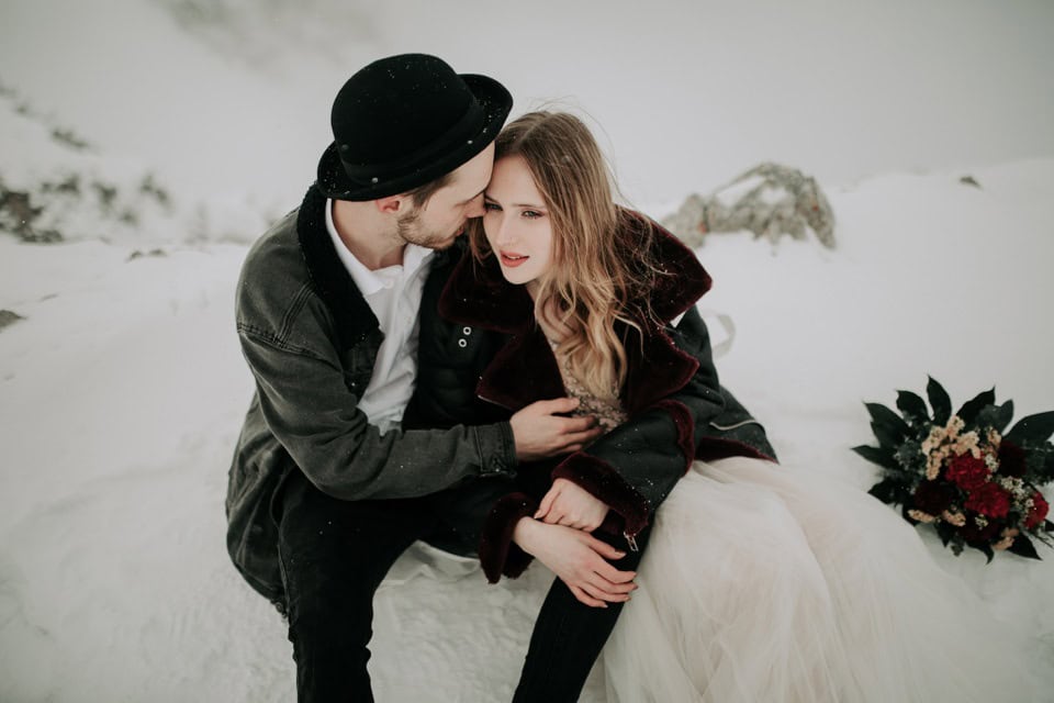 Elegantes Hochzeitspaar im Schnee, romantische Winterhochzeit in Tirol, Österreich, professionelle Hochzeitsfotografie.