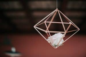 Metallener Cube mit weißer Rose als Hochzeitsdeko, Nahaufnahme, romantische Atmosphäre.