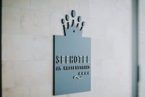 Moderne Hotelauszeichnung mit Kronensymbol und Stil-Logo am Tiroler Seehotel.