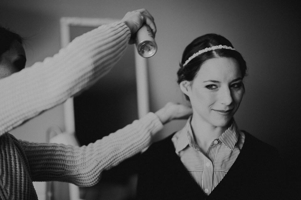 Glückliche Braut wird fertiggestylt vor der Hochzeit in Tirol.
