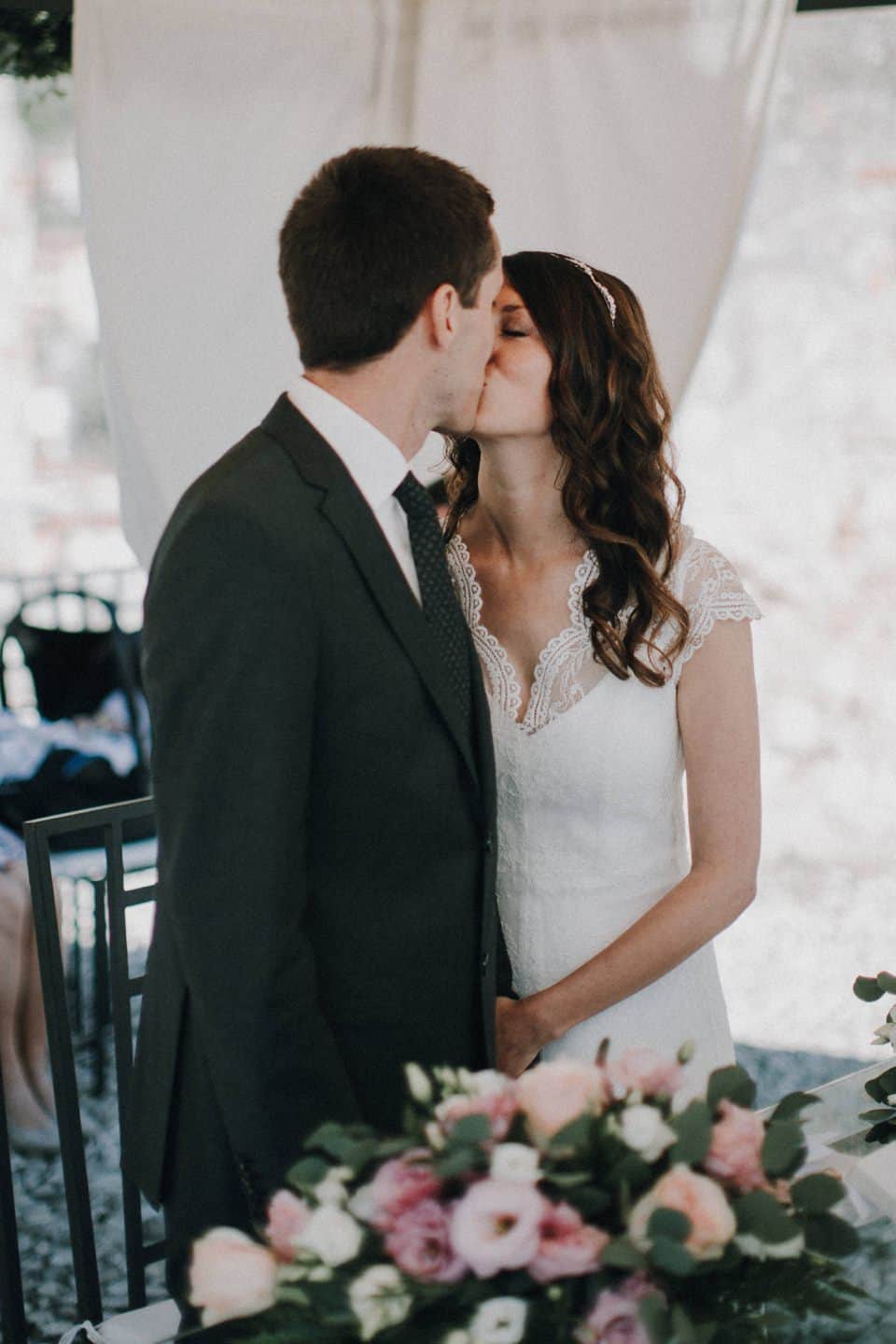 Kuss bei einer Hochzeitszeremonie, Braut und Bräutigam in Liebe verbunden, romantischer Moment, emotionale Hochzeit, Hochzeit in Tirol Österreich.