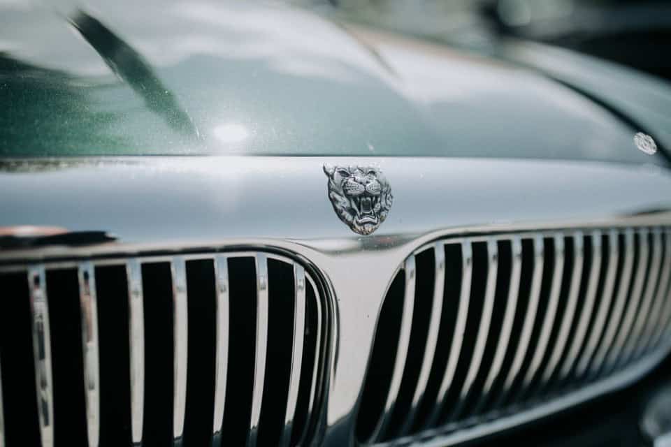 Luxusautomobil mit Jaguar-Emblem, Nahaufnahme der Fahrzeugfront in Schwarz-Weiß.