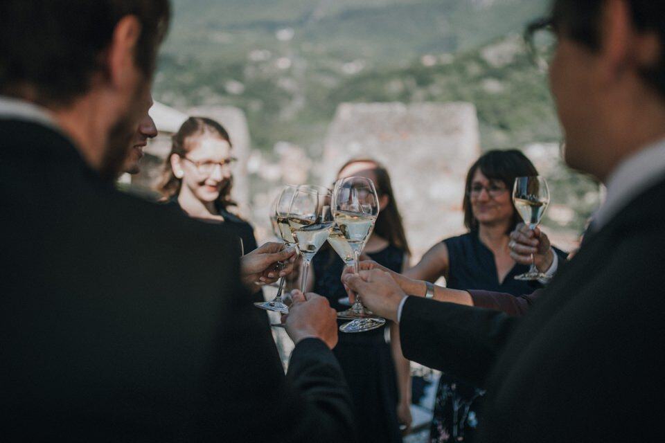 Hochzeit, Freunde stoßen mit Sektgläsern bei einer Feier im Freien an.
