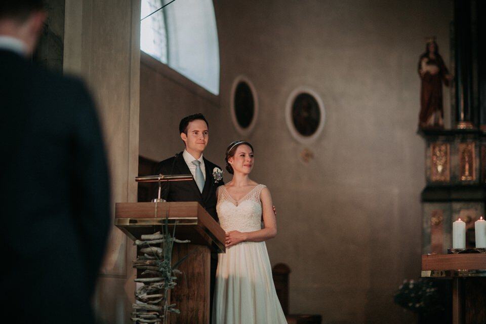 Hochzeitszeremonie in einer Kirche in Tirol, Österreich, mit braut und bräutigam vor einem Altar.
