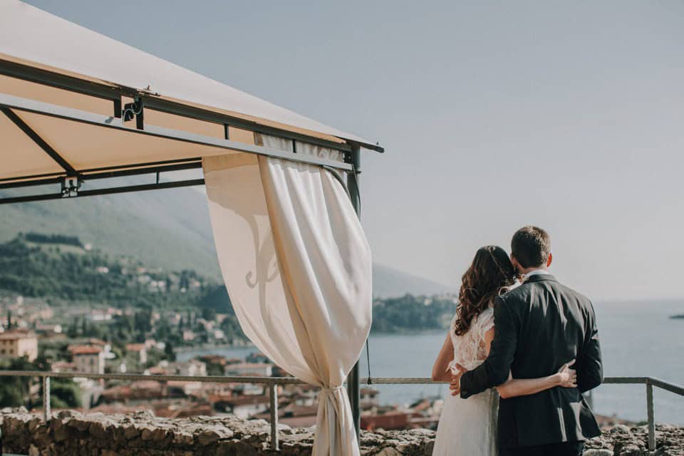 Traumhaftes hochzeitsfoto in tirol mit berge und meer, romantisches ehepaar in stilvoller kleidung.