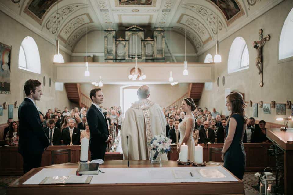 Hochzeitszeremonie in einer malerischen Kirche, gefeiert mit Familie und Freunden, professionelle Hochzeitsfotografie in Tirol, Österreich.