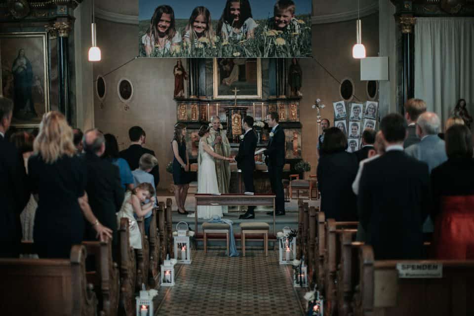 Hochzeitszeremonie in einer Kirche mit jubelnden Gästen und festlicher Atmosphäre in Tirol, Österreich.