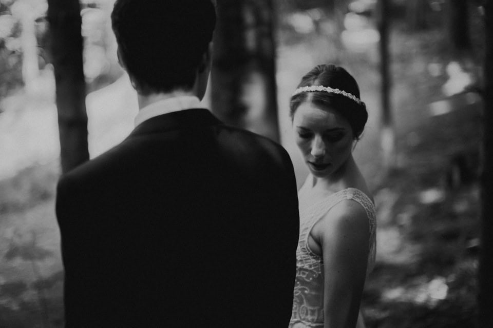 Stilvolles Hochzeitsfoto eines Paares im Wald, schwarz-weiß.