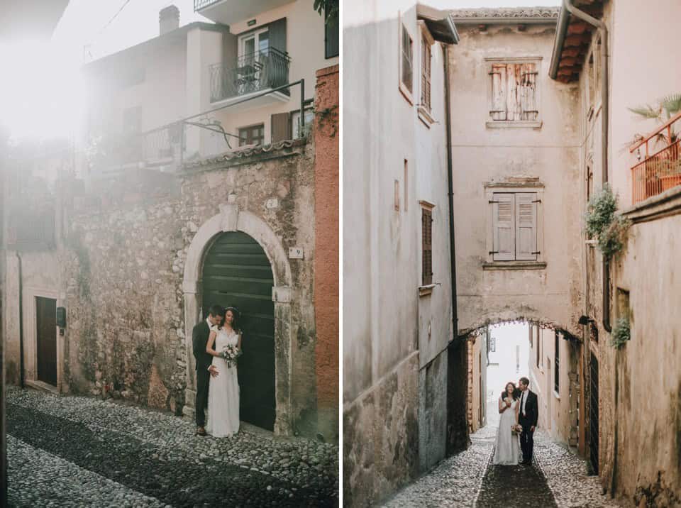 Romantisches Hochzeitsfoto vor alter Stadtmauer in Tirol, Österreich, bei Sonnenlicht.