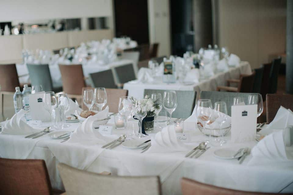 Eleganter Hochzeitsbankett-Tisch mit weißen Stoffen, Kerzen und stilvoller Dekoration für unvergessliche Momente.