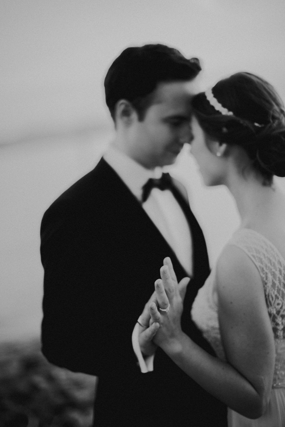 Romantisches Hochzeitsfoto von einem Brautpaar, das sich innig berührt und liebevoll umarmt.