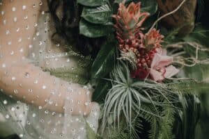 Blumengesteck und Brautkleid mit Perlen, Hochzeitsfotografie, Detailaufnahme, Tirol Österreich.