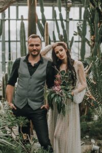 Blumenhochzeit im Gewächshaus mit Braut und Bräutigam in natürlicher Umgebung.