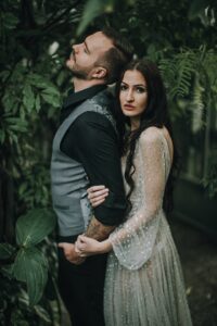 Romantisches Hochzeitsfoto eines Paares in einer grünen Naturkulisse, emotional und stilvoll festgehalten.