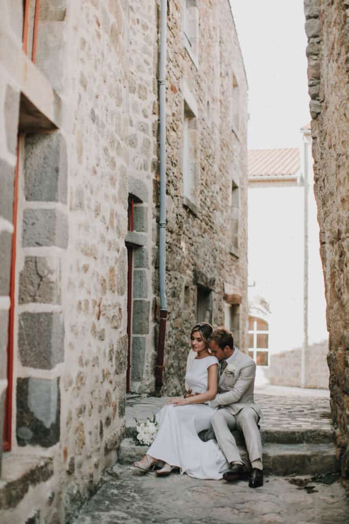 Romantisches Hochzeitsfoto eines Paares in einer alten Gasse mit Steinmauern.