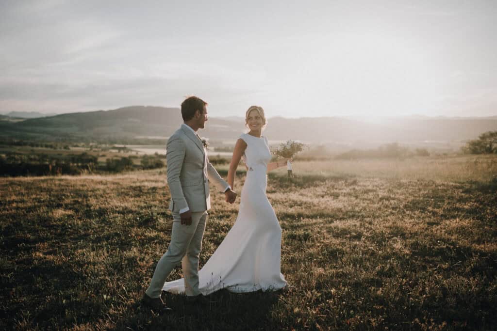 Hochzeitsfotograf Tirol Österreich, Brautpaar im Sonnenuntergang auf dem Feld.
