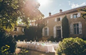 Elegantes Hochzeitsessen im Freien vor einem historischen Haus bei Sonnenuntergang.