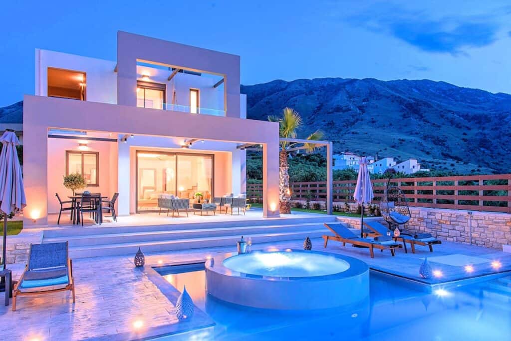 Moderne Villa mit Pool bei Sonnenuntergang in Tirol - Österreich.