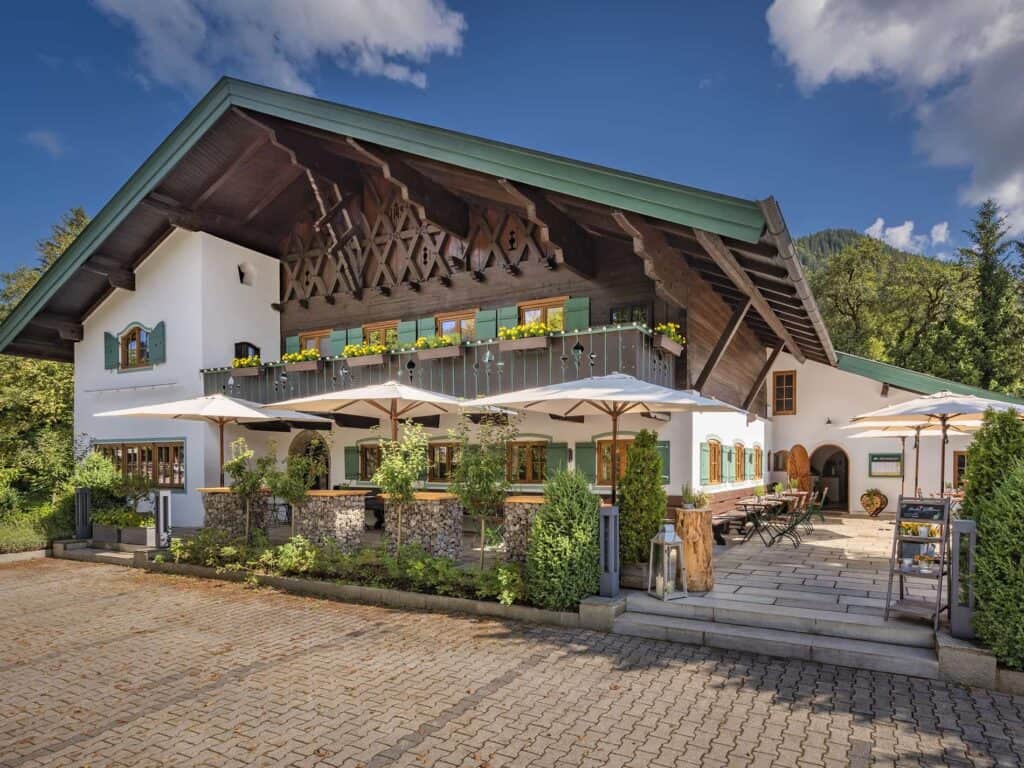 Gemütliches altes Tiroler Gasthaus mit typischer Architektur, Balkon mit Blumen und sonnigem Außenbereich.