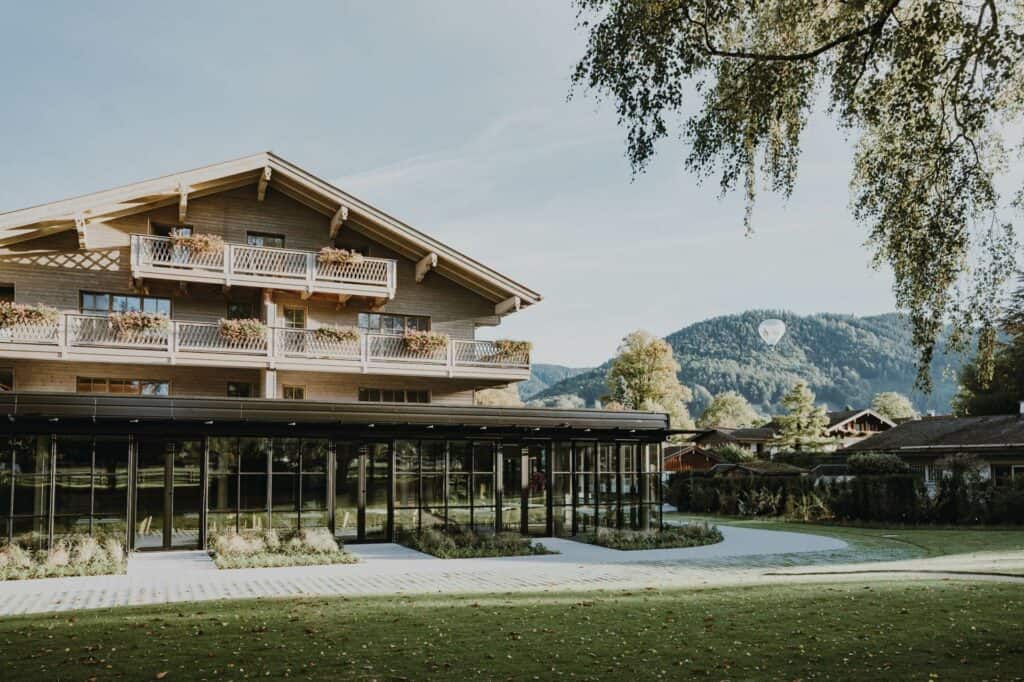 Historisches Hotel in Tirol mit modernen Glas-Anbauten und malerischer Bergkulisse.