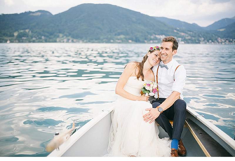 Traumhaftes Hochzeitsfoto am See in Tirol, Österreich, mit glücklichem Brautpaar im Boot.