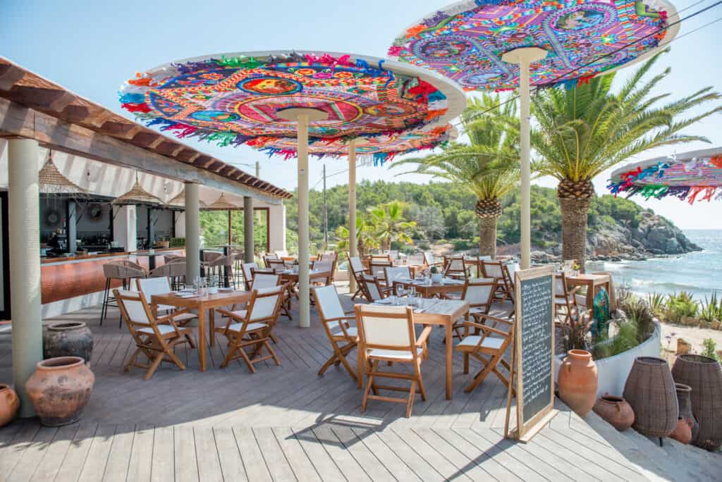 Bunte Sonnenschirme und Strandrestaurant an der Bucht in Tirol, perfekt für Hochzeiten am Meer.