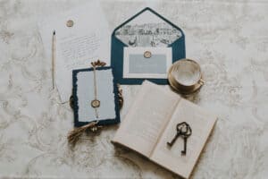 Hochzeitsdetails mit Briefen, Schlüssel, Buch und Schlüssel am eleganten Tisch.