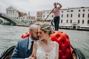Romantisches Hochzeitsfoto in Venedig mit Brautpaar auf Gondel bei Canal Grande, emotionale Hochzeit im Italienstil, professionelle Hochzeitsfotografie, Tirol Österreich, international.