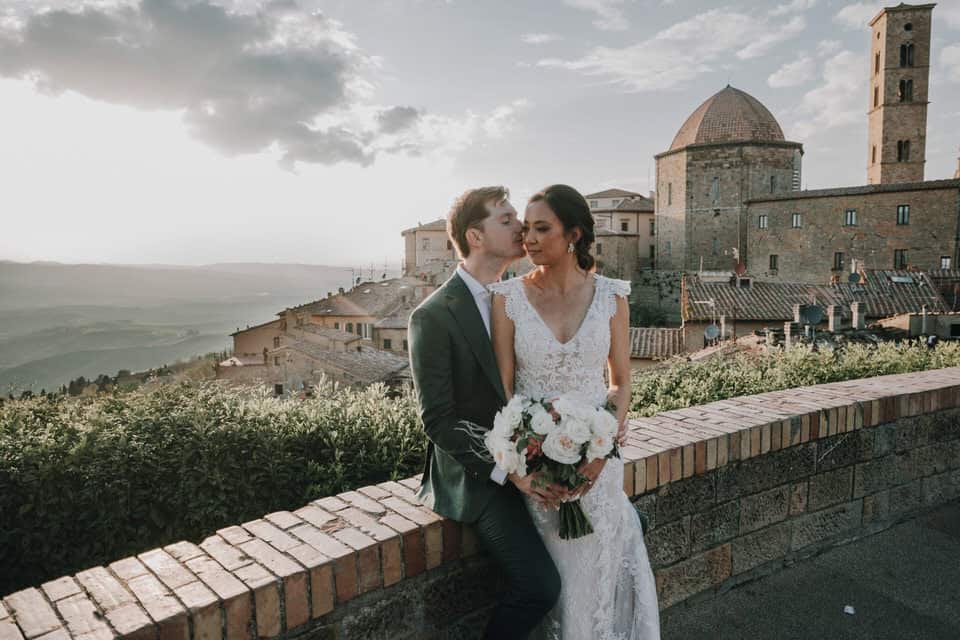 Romantisches Hochzeitsfoto mit Braut und Bräutigam vor historischer Kulisse in Tirol, Österreich.