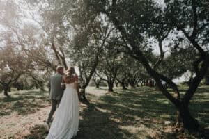 Romantisches Hochzeitsfoto im Sonnenlicht in einem Apfelhain, aufgenommen von Forma Photography in Tirol.