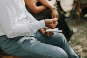 Stimmungsvoller Moment bei einer Hochzeit, Detailaufnahme eines sitzenden Gastes im Anzug.