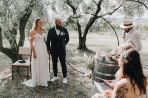 Romantische Hochzeitszeremonie im Grünen unter Olivenbäumen in Tirol.