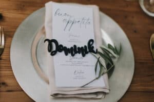 Elegante Hochzeitsmenükarte mit "Dominik" Schriftzug auf silbernem Teller, nostalgisches Hochzeitsthema, tiroler Hochzeit, Hochzeitsfotografie.