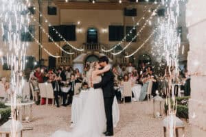 Brautpaar küsst sich auf einer Hochzeit in Tirol, umgeben von Feuerwerk.