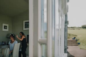 Braut bekommt Frisur mit Blumenkranz vor der Hochzeit in Irland. Hochzeitsfotograf Irland.