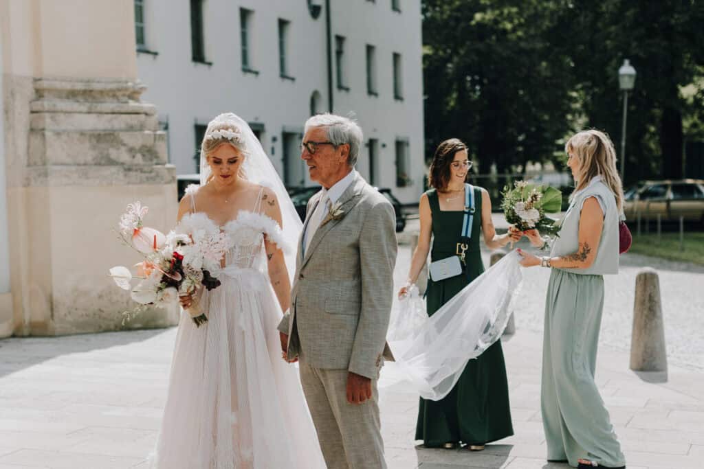 Braut mit Vater und Brautjungfern im Freien. Hochzeitsfotograf München.