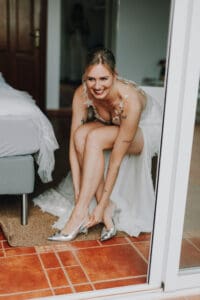 Braut zieht silberne Schuhe an. Glückliche Braut, Ibiza Hochzeit.