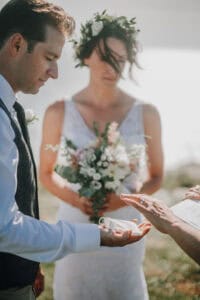 Brautpaar bei Hochzeitszeremonie mit Blumenkranz und Ringübergabe. Hochzeitsfotograf Irland.