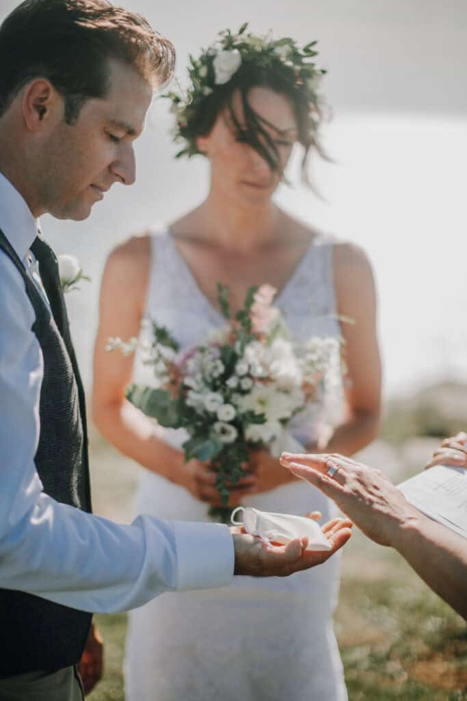 Brautpaar bei Hochzeitszeremonie mit Blumenkranz und Ringübergabe. Hochzeitsfotograf Irland.