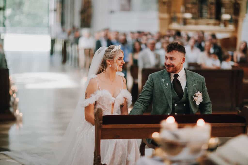 Brautpaar lächelt sich in Kirche an. Hochzeitsfotograf München.