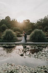 Brautpaar küsst sich im Park bei Sonnenuntergang. Romantische Hochzeit in München.