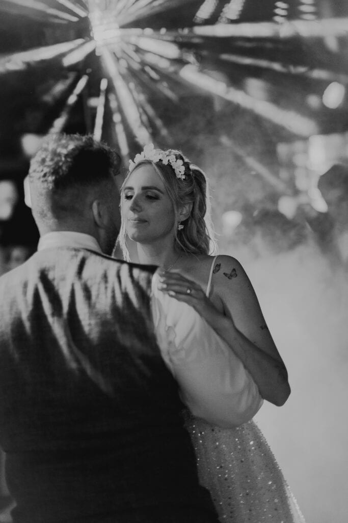 Brautpaar tanzt eng umschlungen. Die Braut trägt einen Blumenkranz. Hochzeitsfotograf München.