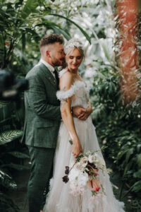 Brautpaar umarmt sich innig im Grünen. Romantische Hochzeit, München.